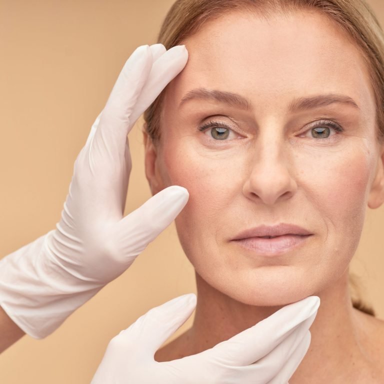 Beautician hands in white gloves checking female face skin before medical therapy. Beauty treatment and wellness concept